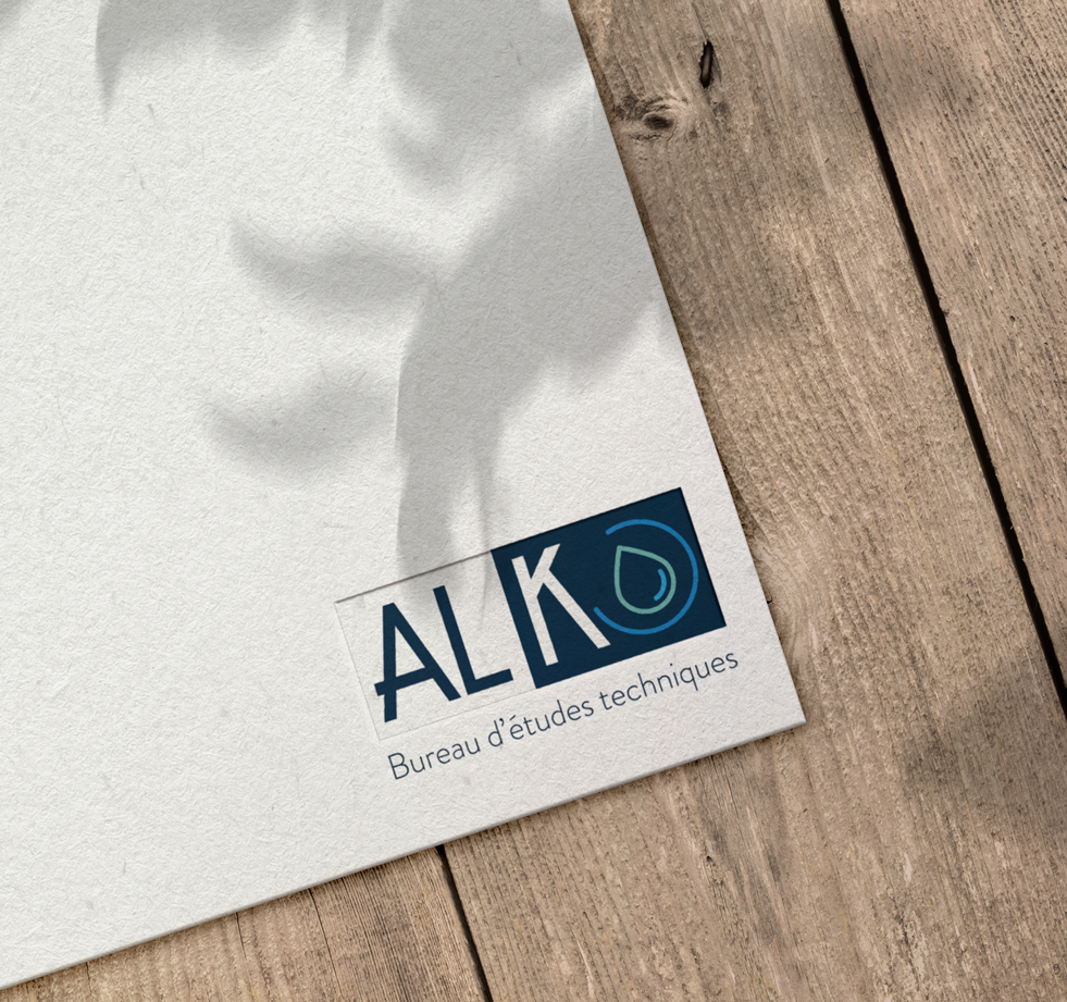 Carte de visite ALKO posée sur un plan de travail en bois